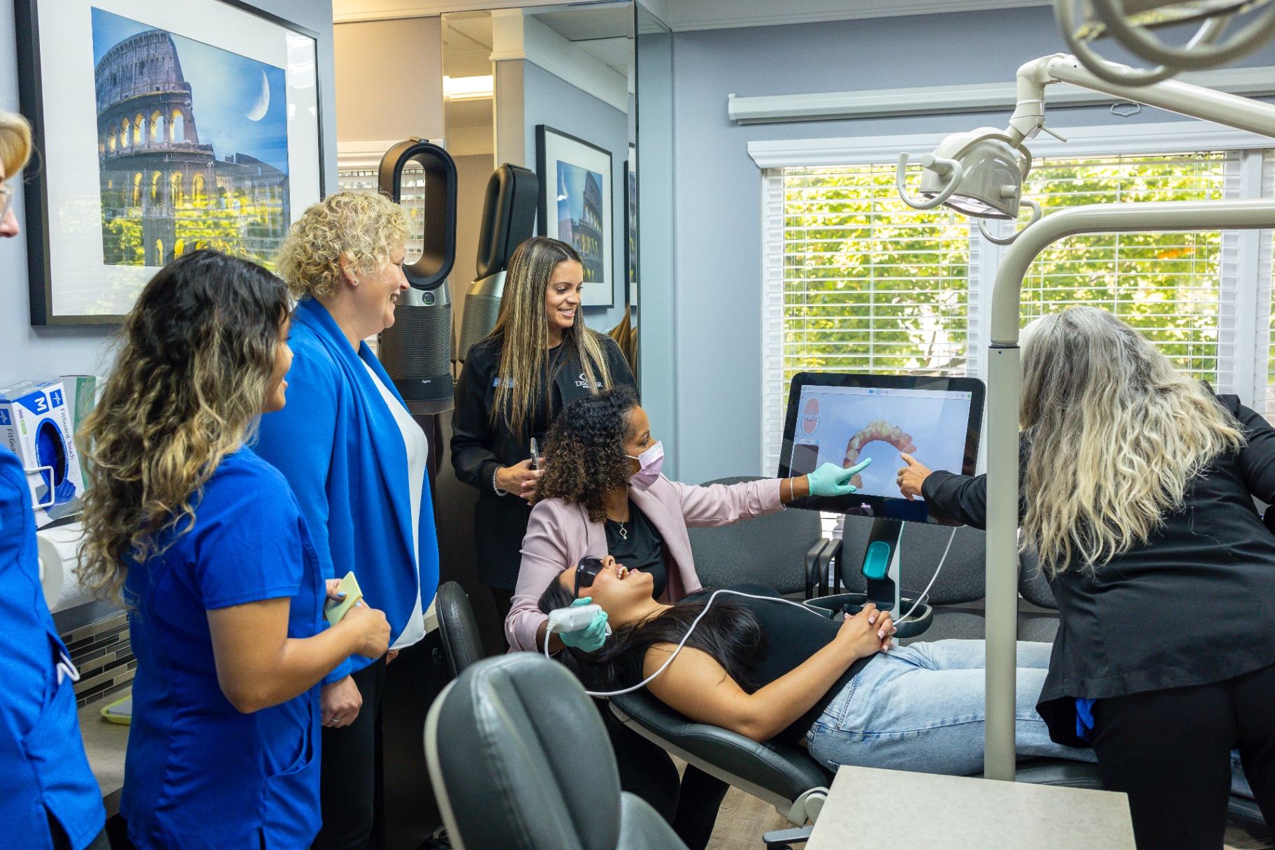 Debbie Khedoo leading an in-practice consulting session with a clinical team around a digital scanner
